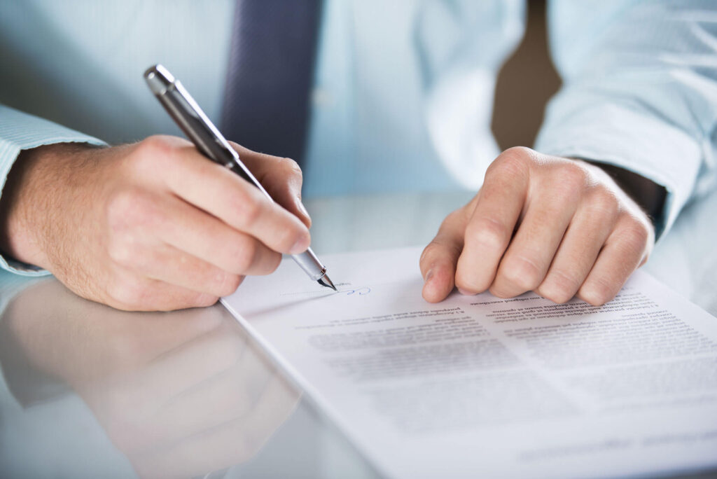 A person is writing on paper with a pen.