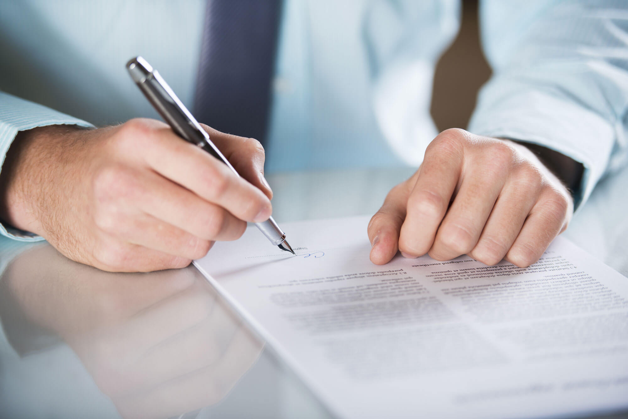 A person is writing on paper with a pen.