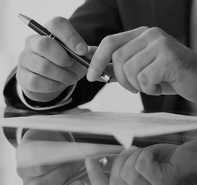A person writing on paper with a pen.